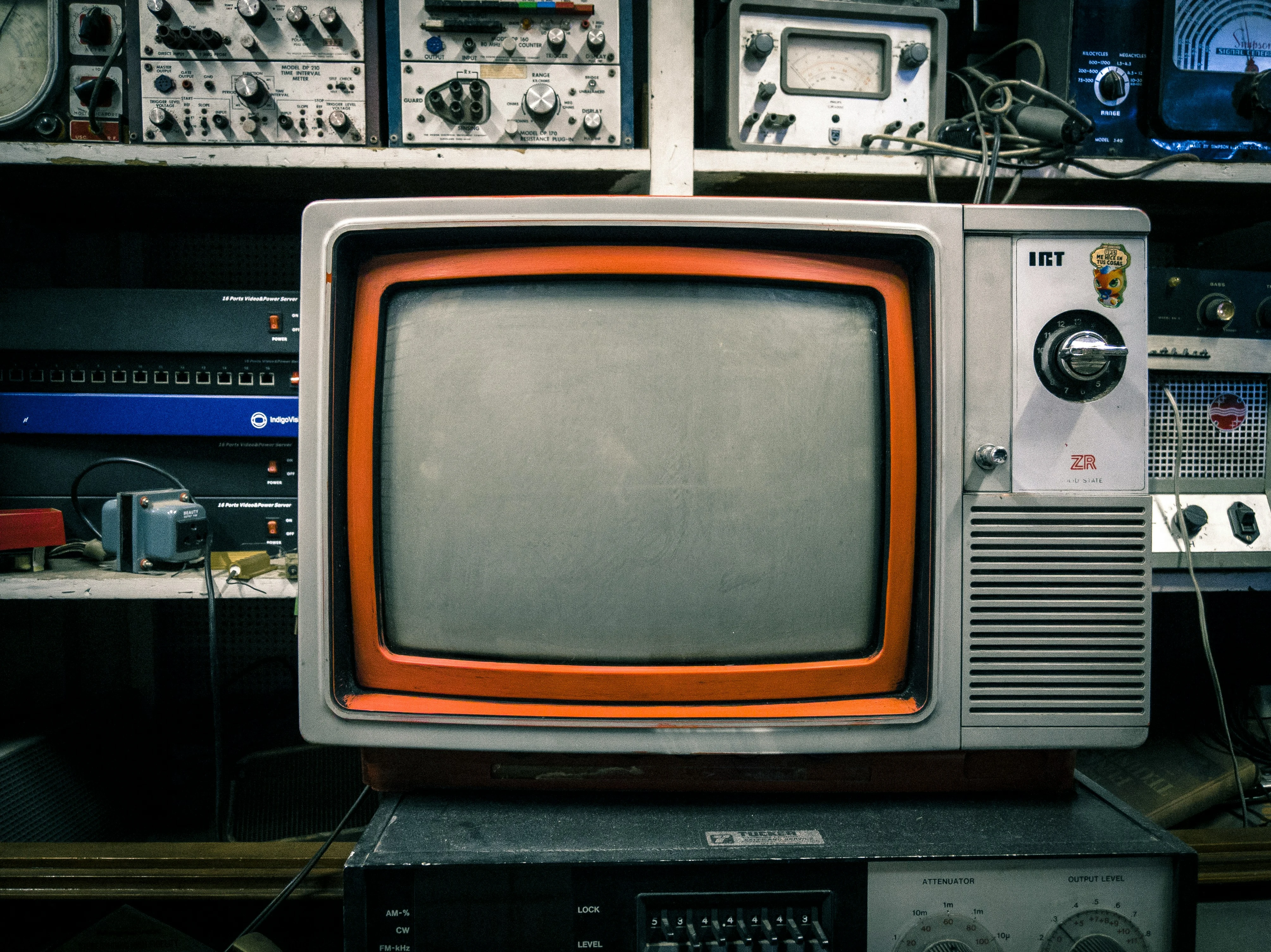 A vintage television surrounded by workshop electronics